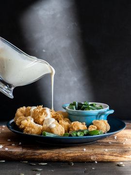 food, breaded chicken slices topped with white gravy boat sauce, serving example
