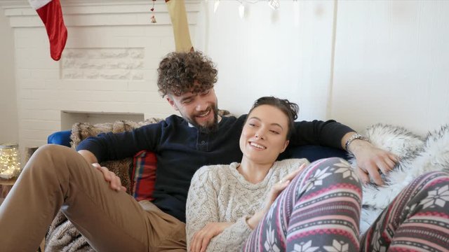 Affectionate couple relaxing in Christmas living room
