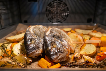 Filled sea bream on baked vegetables in the oven