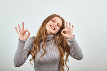 Pretty woman grey sweater gesticulating with hands emotions lifestyle. Squinting eyes