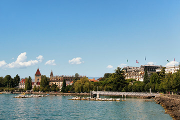 Chateau Ouchy and Lake Geneva promenade in Lausanne, Switzerland. People on the background