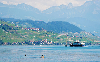 Lausanne, Switzerland - August 26, 2016: People swimming and water ferry on Lake Geneva at Ouchy...