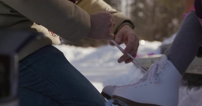 Father Tying Daughter's Ice Skates