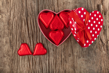 Valentines day with heart shaped box and heart shaped chocolate on wooden background. Top view