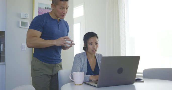 Couple drinking coffee and using laptop