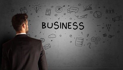 businessman drawing a creative idea sketch with BUSINESS inscription, business strategy concept