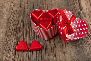 Valentines day with heart shaped box and heart shaped chocolate on wooden background. Top view