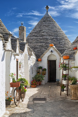 Typical trulli decorated with plants and flowers in Alberobello, Italy
