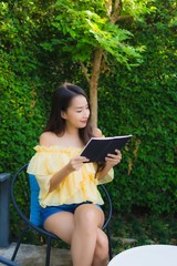 Young asian woman read book around outdoor garden nature