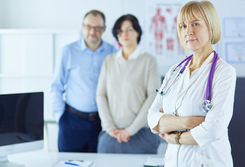 Fototapeta premium Smiling medical doctor with stethoscope and elderly couple