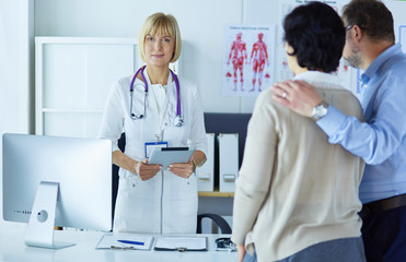 Medical doctor and young couple patients in hospital