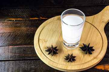 Distilled drink,anise base, on wooden background. Traditional Turkish and Greek appetizer, known as Ouzo, Uzo, Raki, arak or raki arab. Tourist drink.