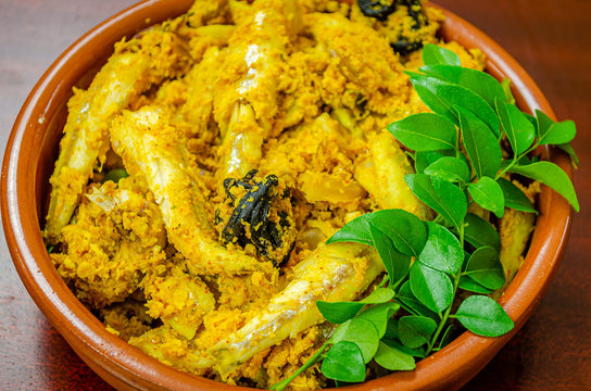 Kerala style fish curry with coconut garnished with fresh green curry leaves
