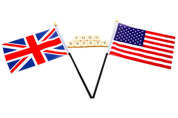 The flags of the United Kingdom and the United States isolated on a white background with a sign reading Food Safety