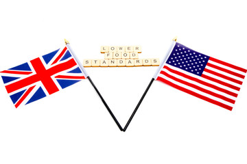 The flags of the United Kingdom and the United States isolated on a white background with a sign reading Lower Food Standards