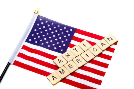 The flag of the United States isolated on a white background with a sign reading Anti American