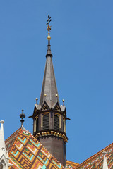 Black tower of the Matthias Church and the roof covered with beautiful hexagonal patterns of...