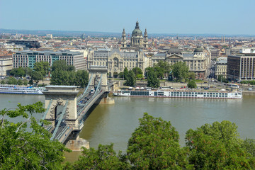Chain bridge on Danube river. View from the Pest side of the urban landscape panorama of the city with old buildings and domes of opera. Budapest, Hungary.