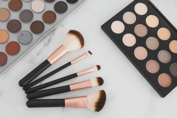 beauty industry and make-up products, eyeshadow palettes with nudes and bronzy tones with brushes