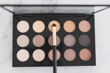beauty industry and make-up products, eyeshadow palettes with nudes and bronzy tones with brushes