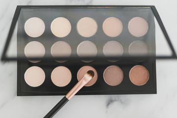 beauty industry and make-up products, eyeshadow palettes with nudes and bronzy tones with brushes