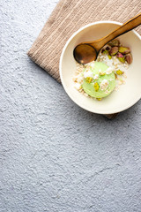Homemade pistachio ice cream with white chocolate on old wooden table. Healthy food. Graphic resource