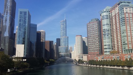 Fototapeta na wymiar Chicago River Amidst Buildings Against Blue Sky
