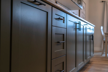 Beautiful cabinetry with black handles and drawers under white countertop
