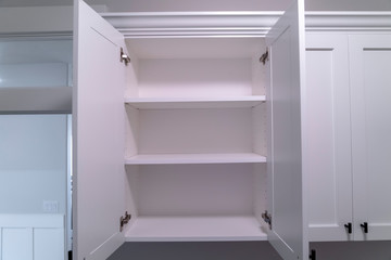 Hanging wall cabinets with open doors and shelves at a new home interior