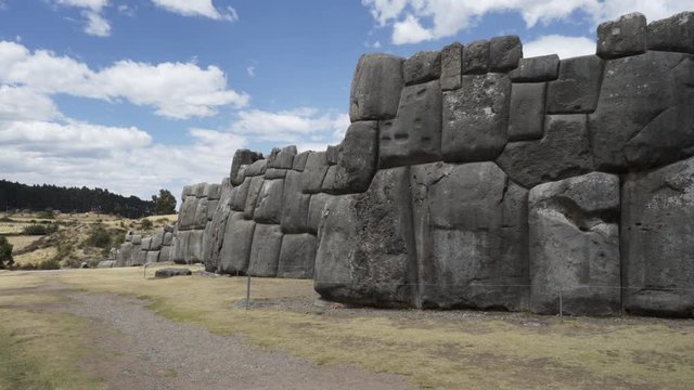 Ancient massive fortress defensive walls at Inca citadel ruins of Sacsayhuaman, Cusco, Peru with huge carved and rounded stone blocks. Traditional Inca construction and architecture.