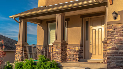 Fototapeta premium Panorama frame Home with stairs leading to the front door and porch against hill and sky view