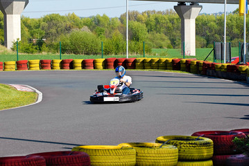Go Cart Rennen mit Fahrer in Sicherheitsbekleidung rasend auf dem Streckenverlauf