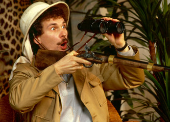 Safari - Mann im Safarilook mit Fernrohr und Gewehr