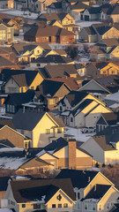 Photo Vertical frame Houses with snowy roofs and snowy yards illuminated by sunlight in winter