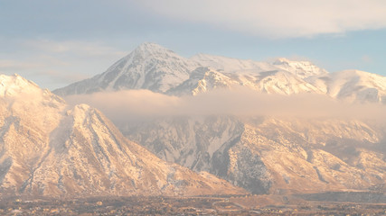 Fototapeta na wymiar Panorama frame Mount Timpanogos hills and houses blanketed with snow on a cold winter day