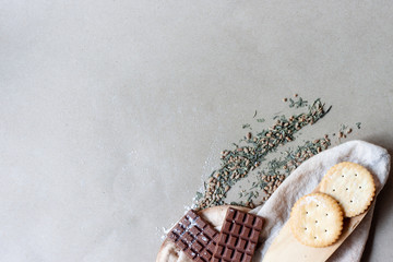 Chocolate, crackers and dried tea leaves with spatula and  filter bags on paper..Breakfast and tea...