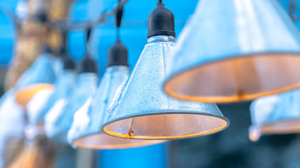 Photo Panorama Cone shaped lamps hanging on black electric string wires against blurry sky