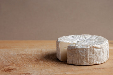 Brie. Cheese cubes that are sliced out on the wooden floor.