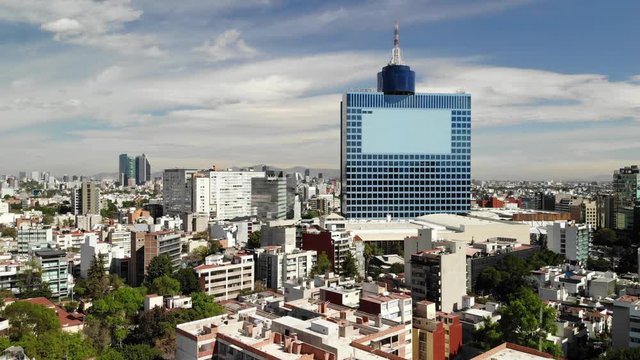 WTC Mexico and the skyline of CDMX, drone flying forward with a blue sky as background
