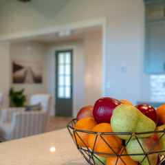 Square frame Fruit basket on a kitchen island with black faucet and double basin sink