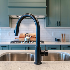 Photo Square frame Double bowl kitchen island sink with black faucet against cooktop and cabinets