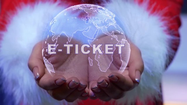 Female hands holding a conceptual hologram of planet Earth with text E-ticket. Woman in red clothes with faux white fur with future holographic technology