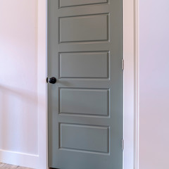 Square frame Glossy gray wooden door with matte black door knob inside a home