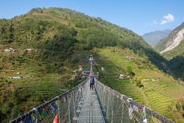 Group of tourist crossing the river by the suspension bridge named 'New Bridge' (278 m long) located nearly Jhinu Danda village, one of the famous village on the way to Annapurna Sanctuary of Nepal.