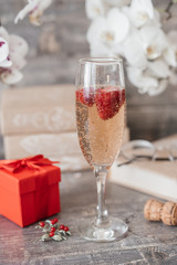 a glass of champagne with strawberries on the table
