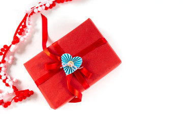 Red gift box with heart and bow on white background. Valentines day 14 february packaging concept. Flat lay, copy space, top view.