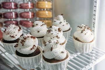 Small cakes lie on the shelf of the refrigerator.