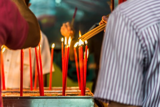 Cropped Image Of Man Burning Incense At Temple