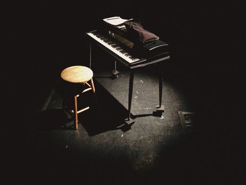 Piano and stool in dark room