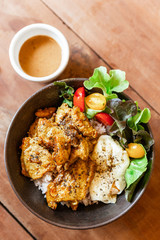 Top view of steam rice with Chicken Satay and fried egg served with salad including green oak and tomato. Served with Satay sauce.